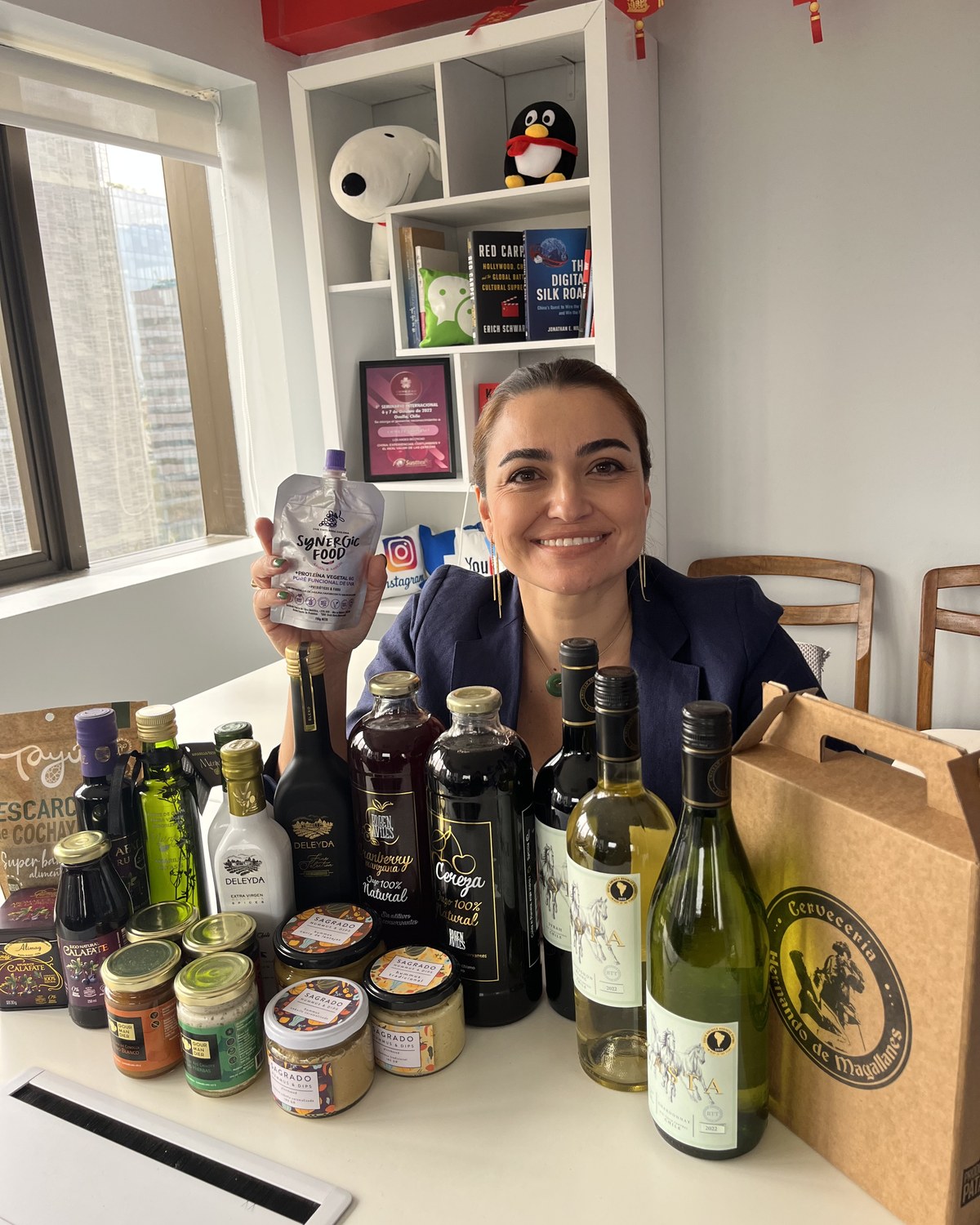 Fiorella Bonino con producto premiado SIAL Synergic Food en oficina China rodeada de portafolio chileno